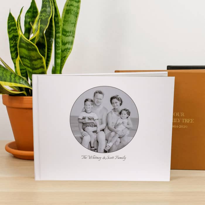 A Family History Book with a custom photo cover showing a vintage photo of the Conklin family sits on a table.
