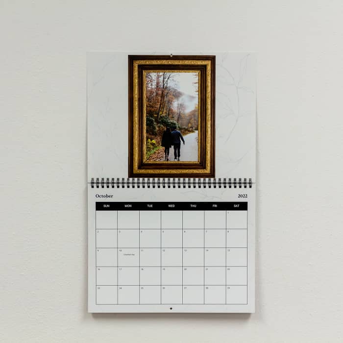 A Family Photo Calendar measuring 11x17 inches when open, hangs on a wall with a custom family vacation photo on display.