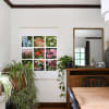 An Engineer Print of 9 flower photos hangs from Maple Poster Rails in a dining room.