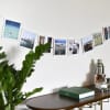 Eight Foil Bordered Square Prints of vacation photos are draped over a bar cart, hanging from a photo rope.