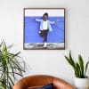 A Square 24 inch Floating Frame Canvas Print in Oak hangs above a leather chair.