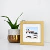 A Gold Square Frame is placed next to a potted plant.