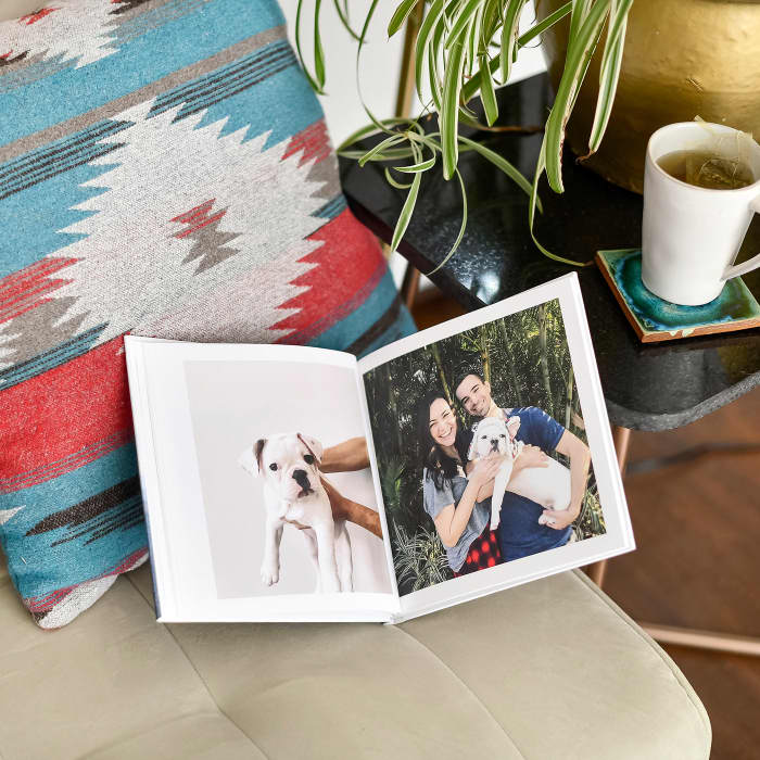 A Hardcover Photo Book is opened to pages showing a puppy and its parents.
