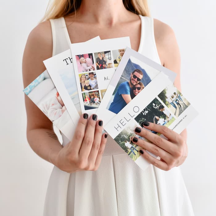 A person holding five custom Photo Greeting Cards fanned out.