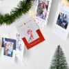 A string of custom photo Holiday Cards are hung from Clip Lights beneath a garland.