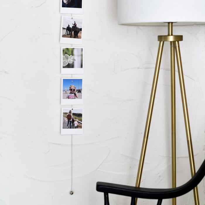 Family photos hang vertically from a Photo Rope, attached with small magnets.