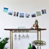 A 58 inch Horizontal Photo Rope full of prints is draped over a a bar cart to display Square Prints.