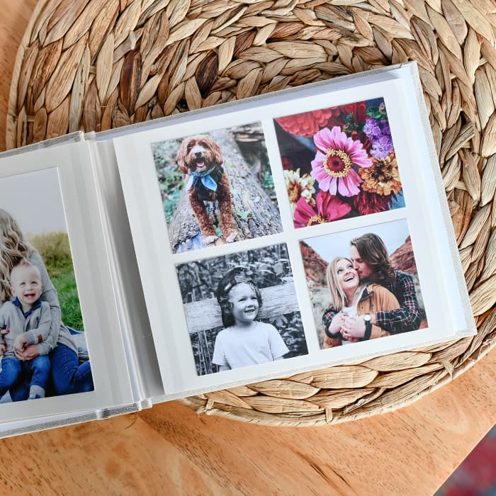 An open Square Print Photo Album holds four Tiny Square Prints of bright family photos.