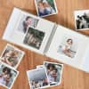 Family photos are scattered around and placed inside a creme linen Square Print Photo Album from Parabo Press.