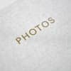 A close up shows the linen texture and gold title reading PHOTOS on the front of a Square Print Photo Album.