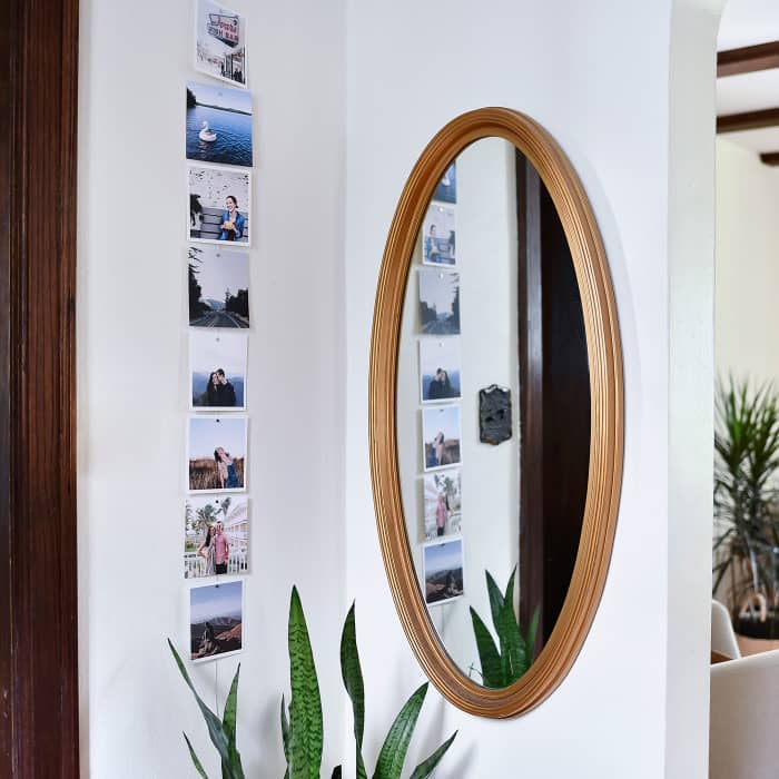 Eight Square Photo Prints hang vertically on a magnetic Photo Rope in an entryway.