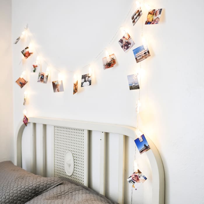 A set of 20 Tiny Square Prints are hung above a headboard using a Clip Lights.