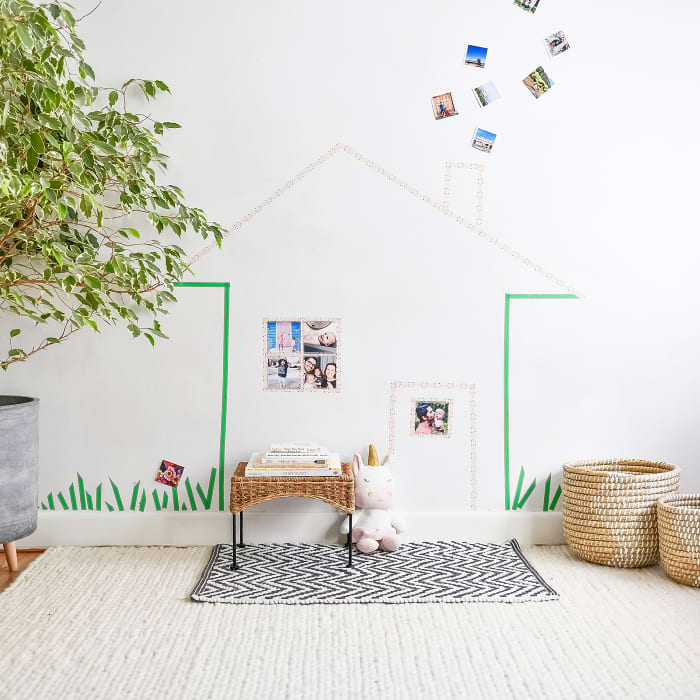 A Washi Tape mural of a house decorates the wall of a child's playroom.