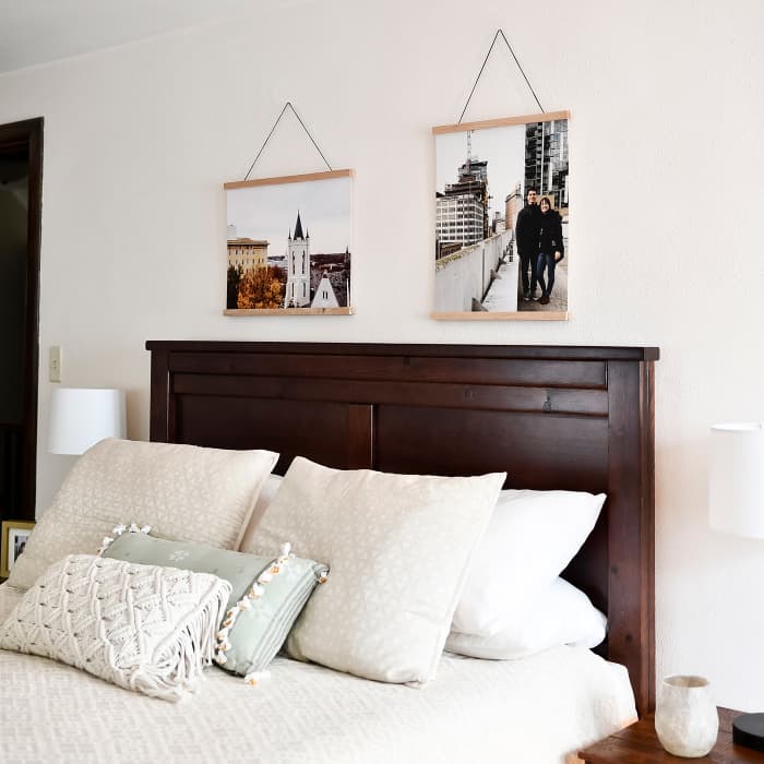 Two Fine Art Prints displaying vacation photos, hang from Oak Wooden Rails above a neatly made bed. 
